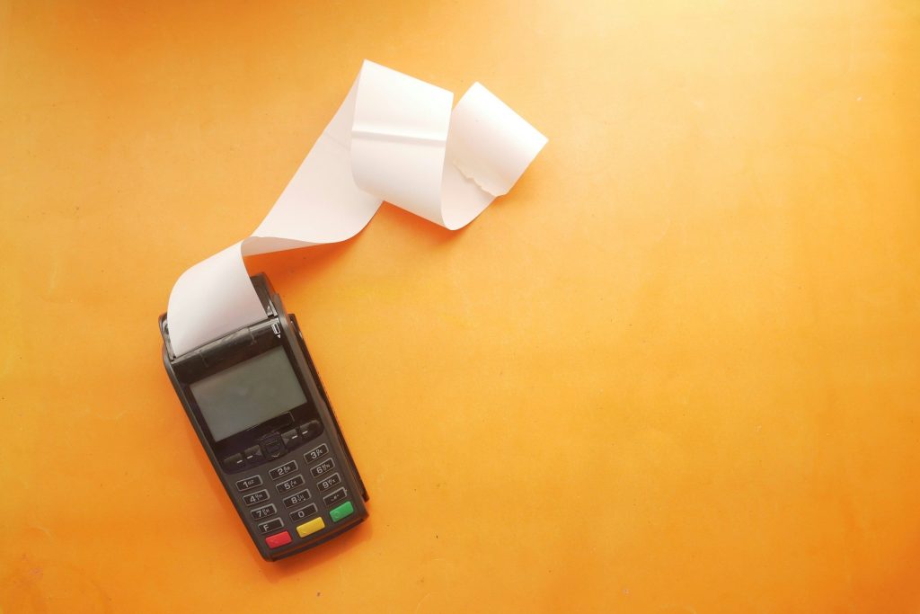 A card terminal with a printed receipt curling out of it