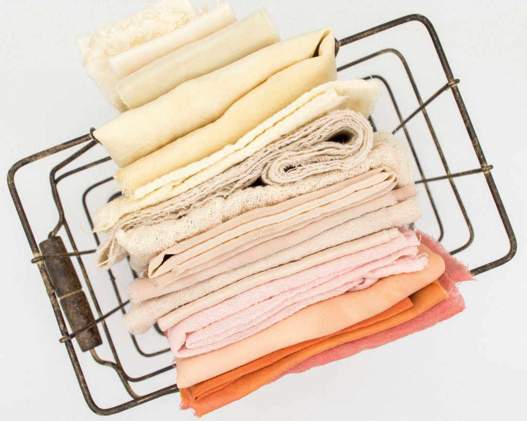 Folded linens stacked in a wire basket