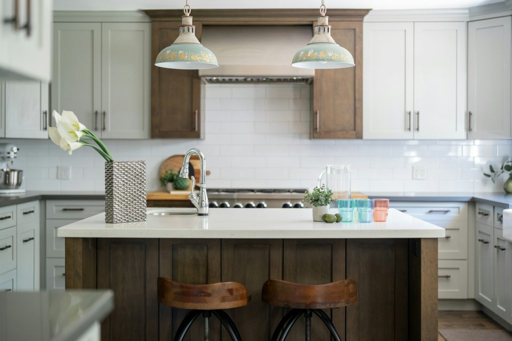 A white kitchen with a timber island and two enamel pendant lights