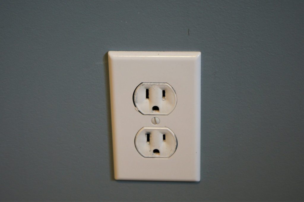 A cream duplex outlet on a grey wall