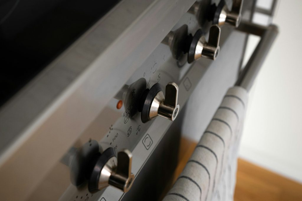 A row of control knobs along the front of a stainless range