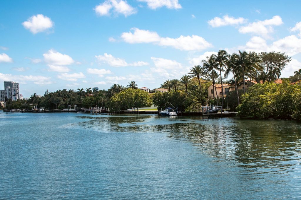 A wooded bank of large houses across a wide bay
