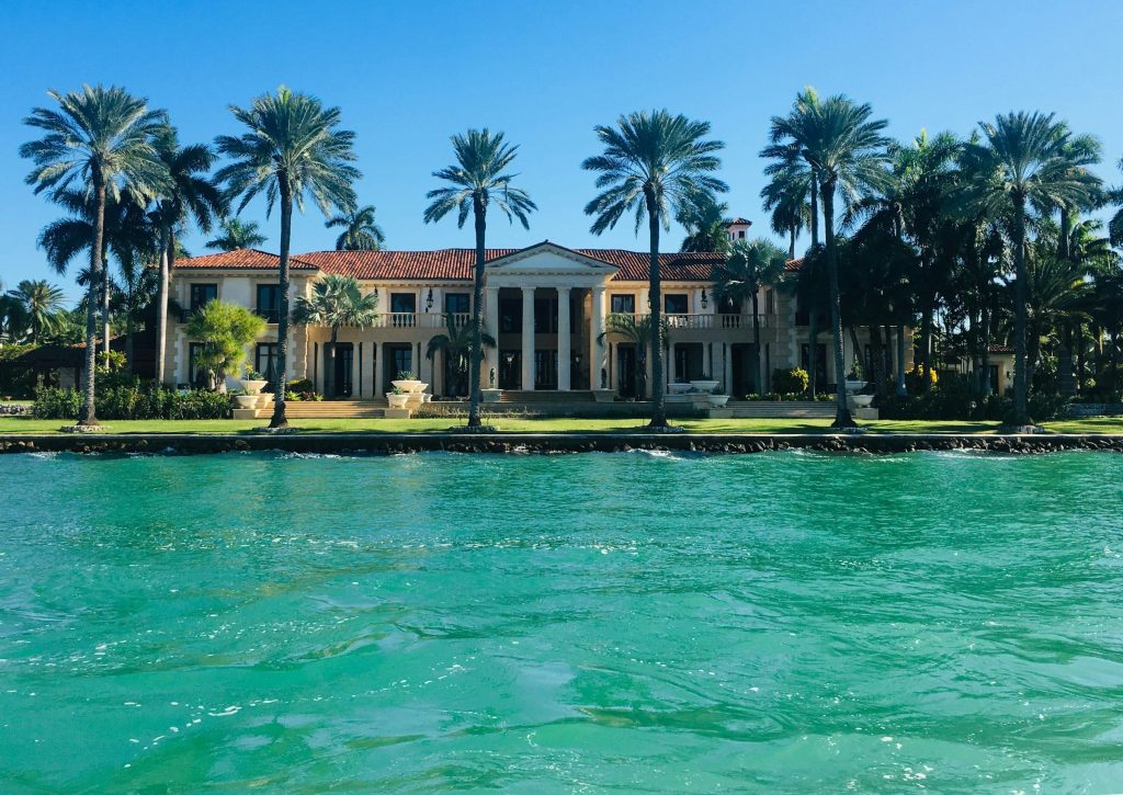 A large bayfront house behind a seawall, seen from the water