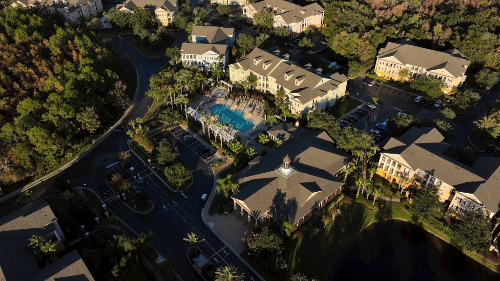 A cluster of low condominium buildings around a pool and a lake