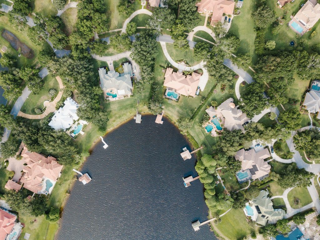 Houses with pools and private docks around a small lake, from above