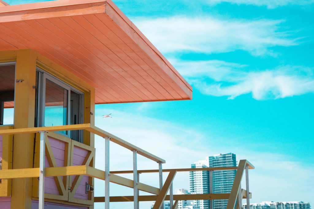 A painted lifeguard hut with residential towers behind it