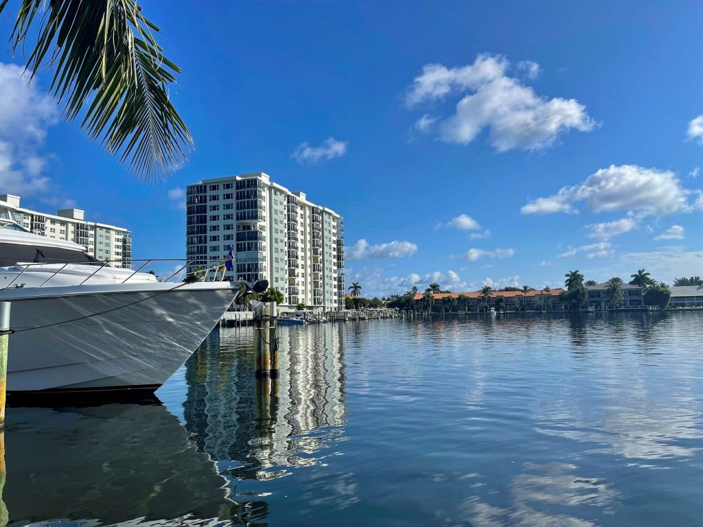 A moored motor yacht in front of a residential tower on the water