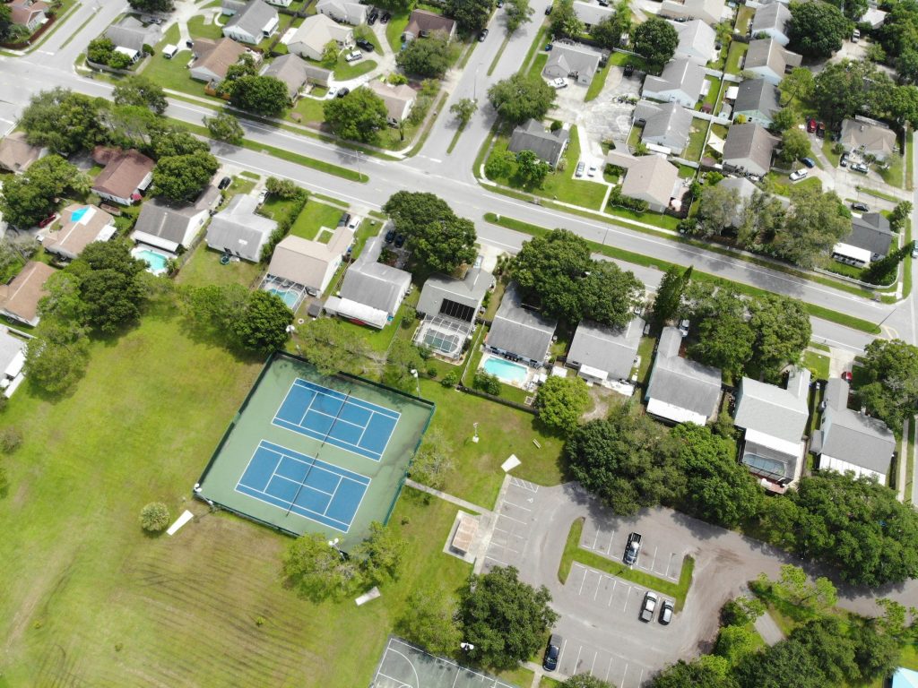 A suburban block with tennis courts and screened pools, from above
