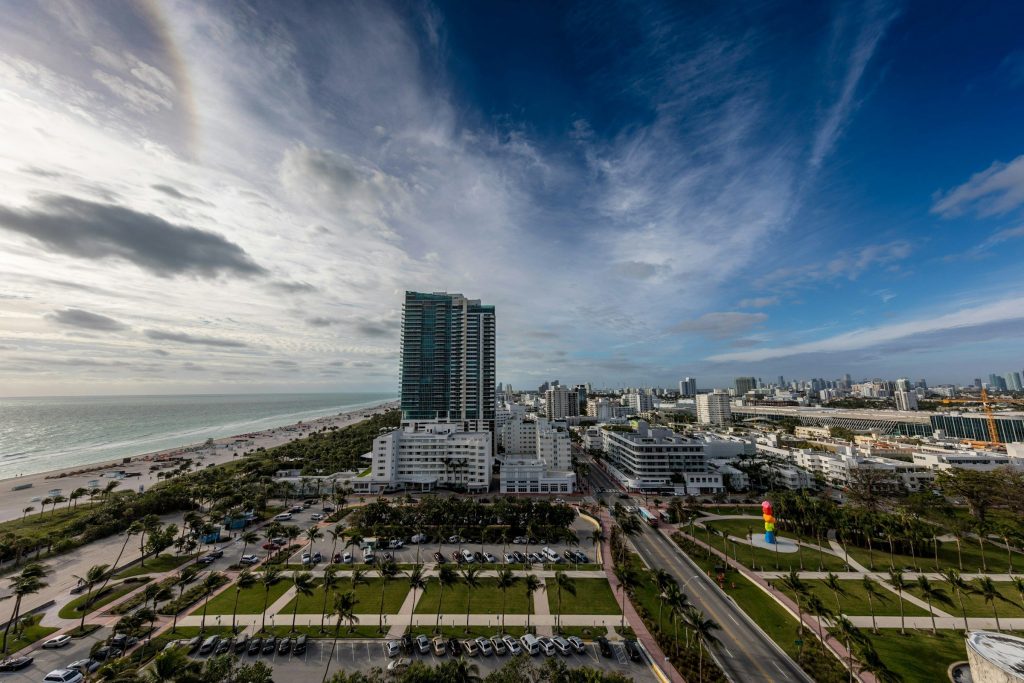 A single tall tower over a park and the beach beyond