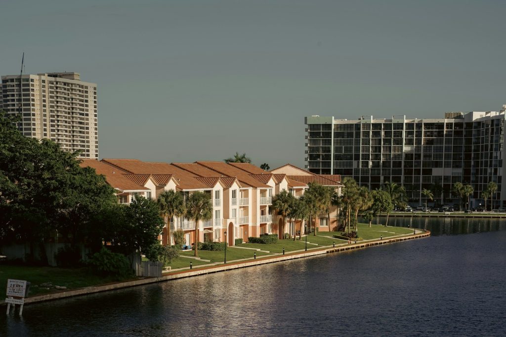 Low condominium blocks on a seawall with towers behind them