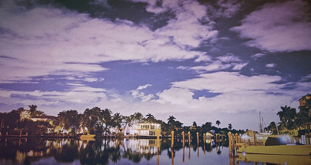Waterfront houses and their docks under a violet evening sky