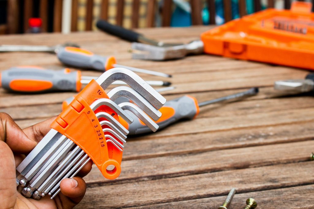 A set of hex keys held over a bench of screwdrivers and an open tool case
