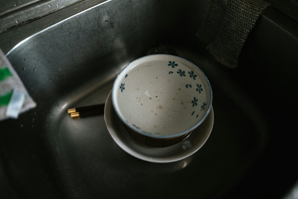 A bowl still marked with food residue, sitting in a sink