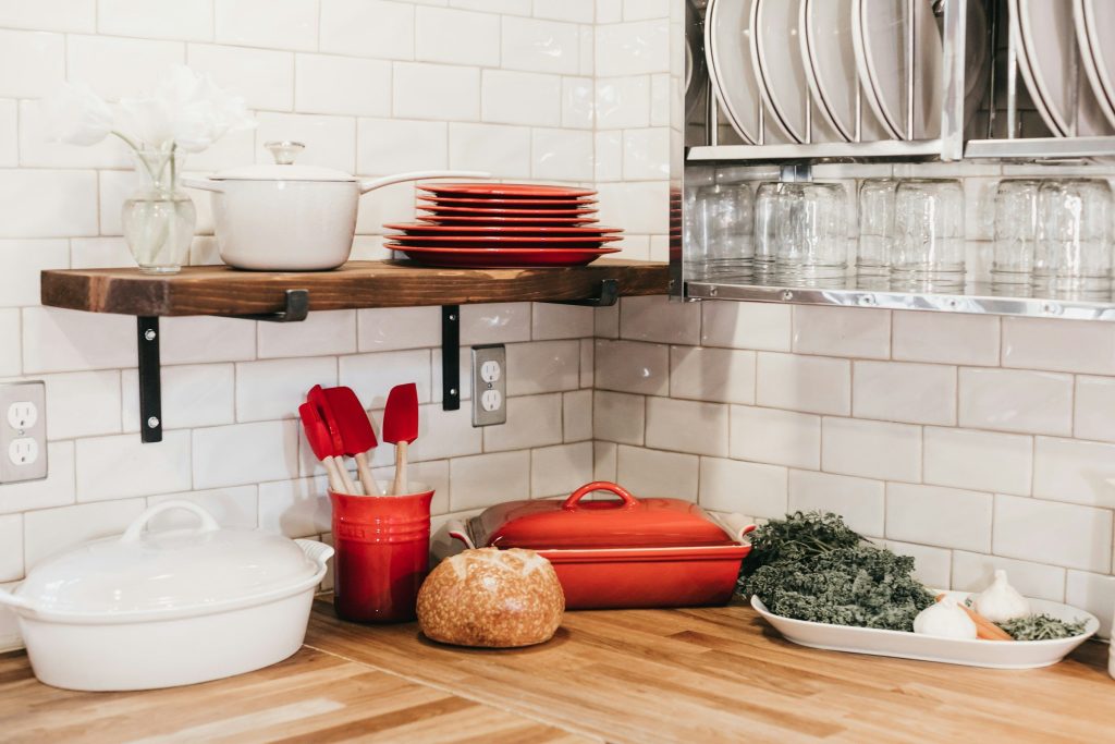 A tidy kitchen corner with a shelf of clean cookware over a wooden counter