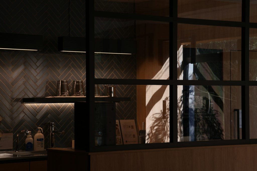 A dark kitchen at night, one strip of light under the cabinets
