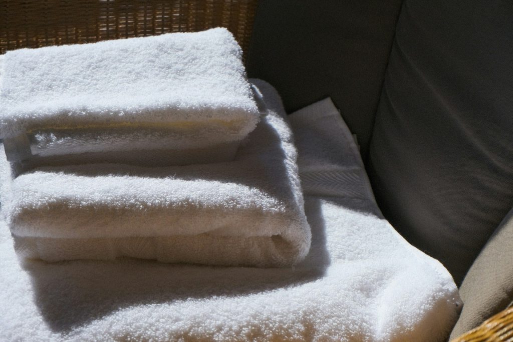 Folded white towels stacked on a dark chair